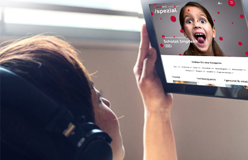 Eine Frau schaut sich liegend das Online-Magazin auf einem Tablet an